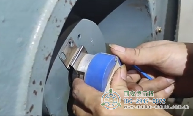 图为工作人员正在对发生飞车现象的电梯编码器进行拆御的照片